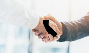 A picture of a handshake for a story about how partnerships could change the outlook for California sports betting prospects.