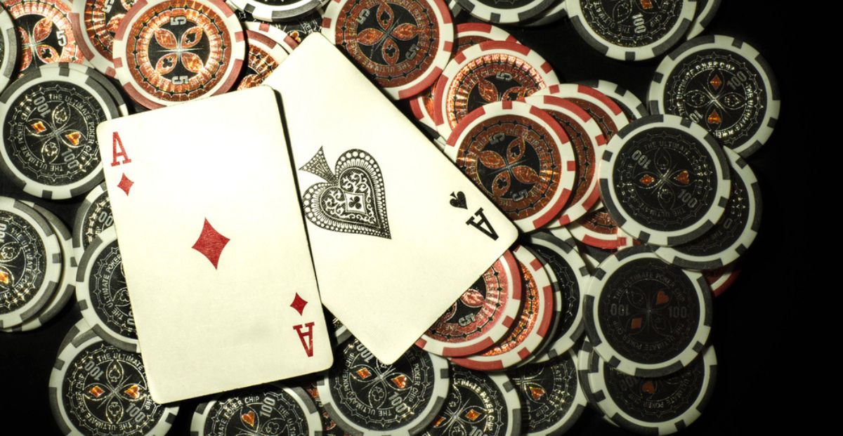 Red And Black Poker Chips Displayed Below Aces Playing Cards