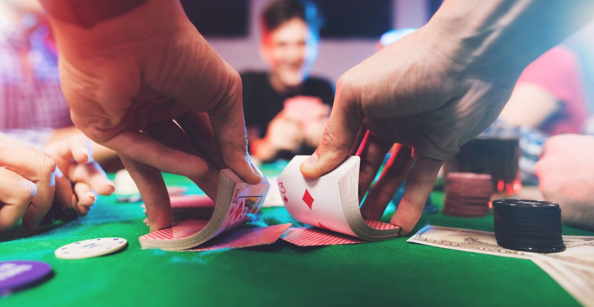 a dealer shuffles cards at a poker table