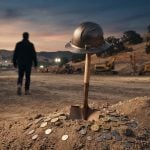 A construction shovel stands upright in a pile of dirt with a hard hat on top, while a person walks away toward construction machinery at dusk.